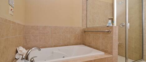 A bathroom with a bathtub, a shower, and a glass-enclosed shower stall.