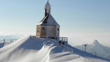 A snow-covered church with a bell tower on a hill.