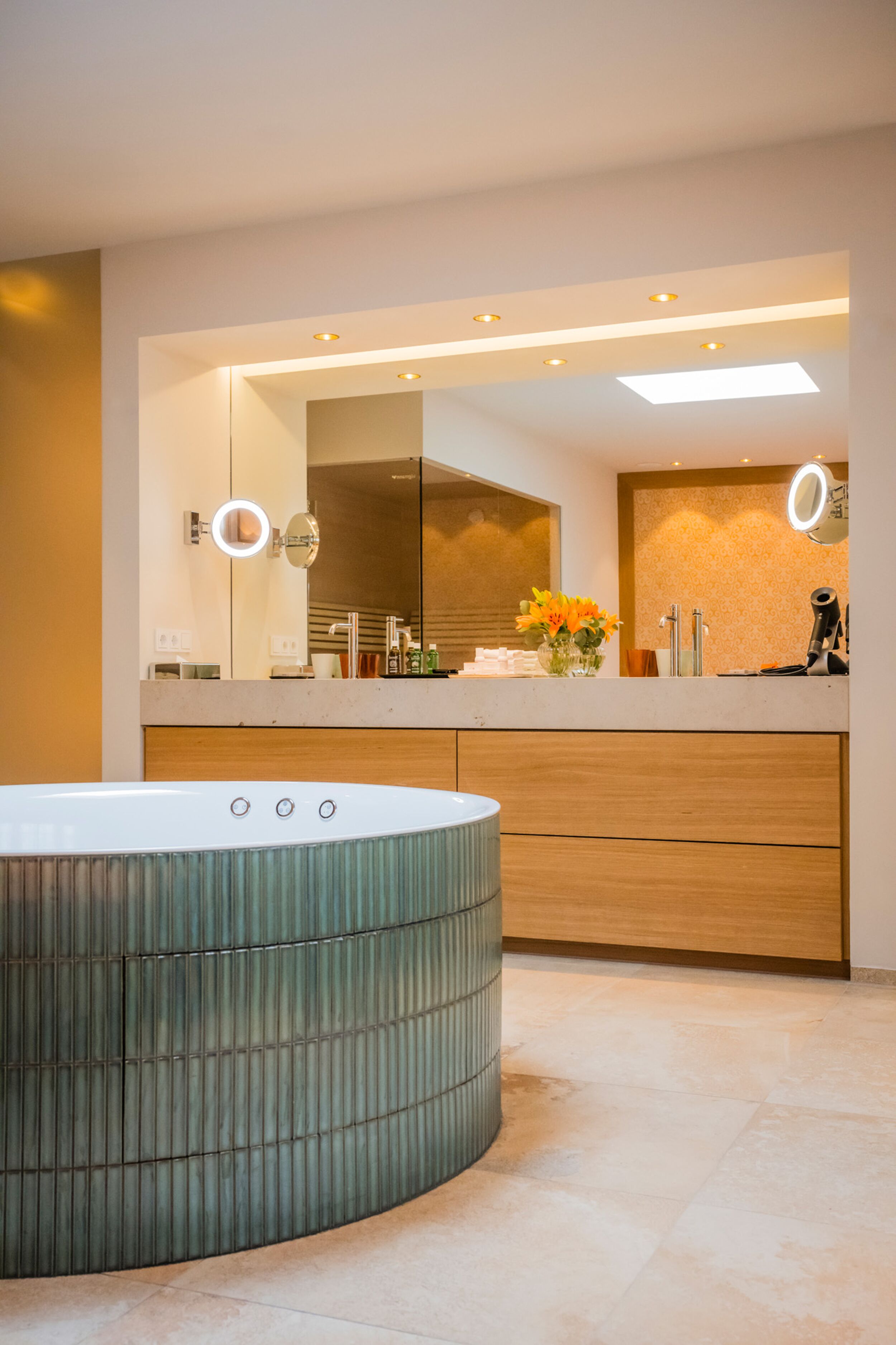 Une salle de bain moderne avec une baignoire sur pieds, un grand miroir et un meuble-lavabo doté d’un évier et d’un plan de travail.