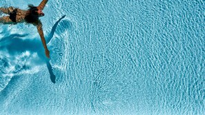 A clear view of a swimming pool with a person swimming. - Spa & Resort Bachmair Weissach, LUXURY FAMILY RESORT (Kreuth)