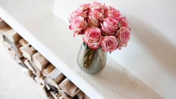 Eine Vase mit rosa Rosen auf einer weißen Oberfläche.