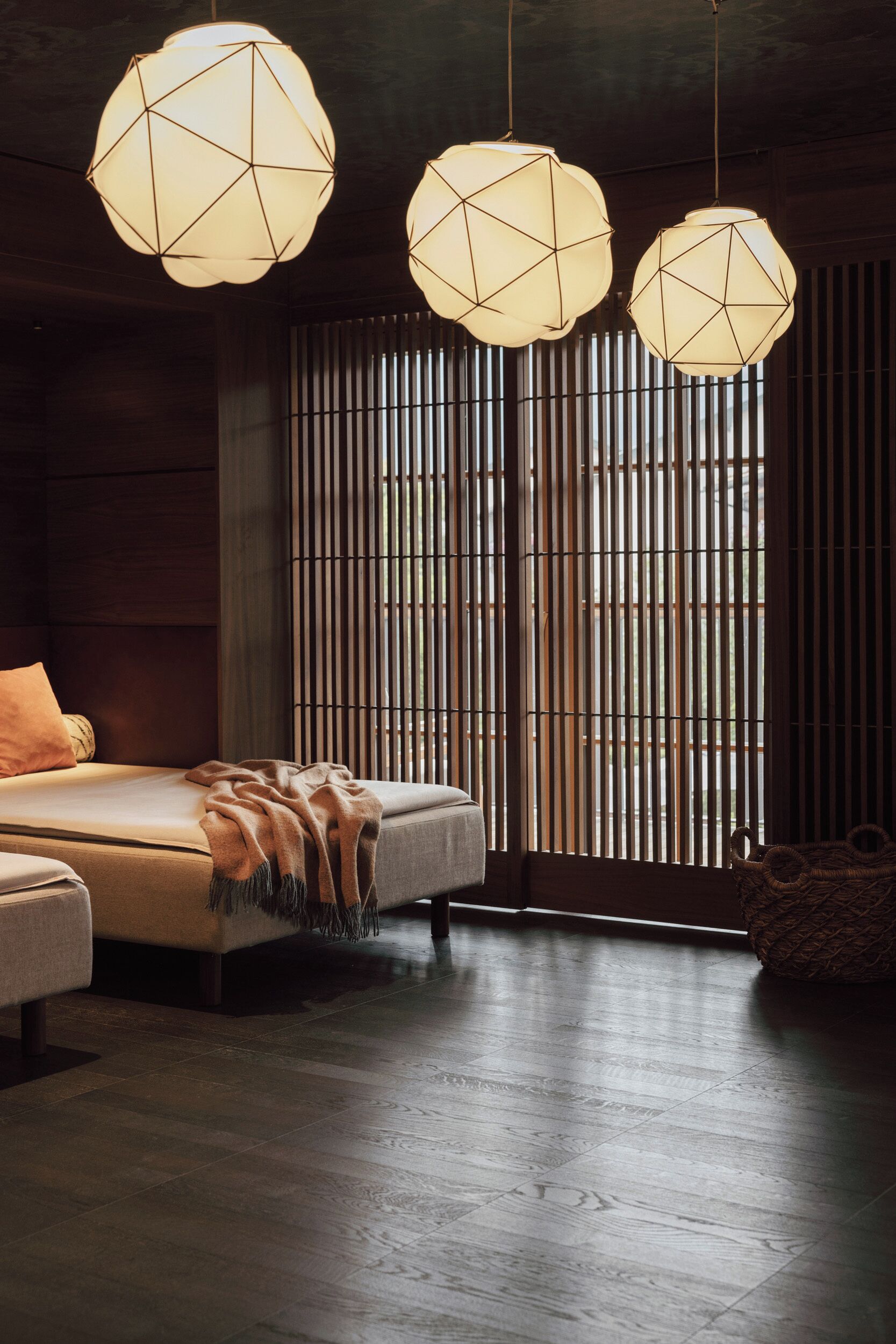 A bedroom with a bed, a bedside table, and a hanging light fixture.