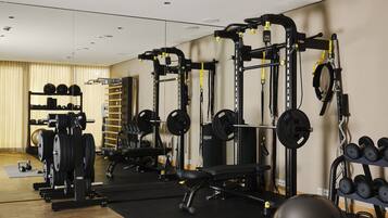 Una palestra con diverse attrezzature per l'allenamento, tra cui macchine per pesi, pesi liberi e palle da ginnastica.