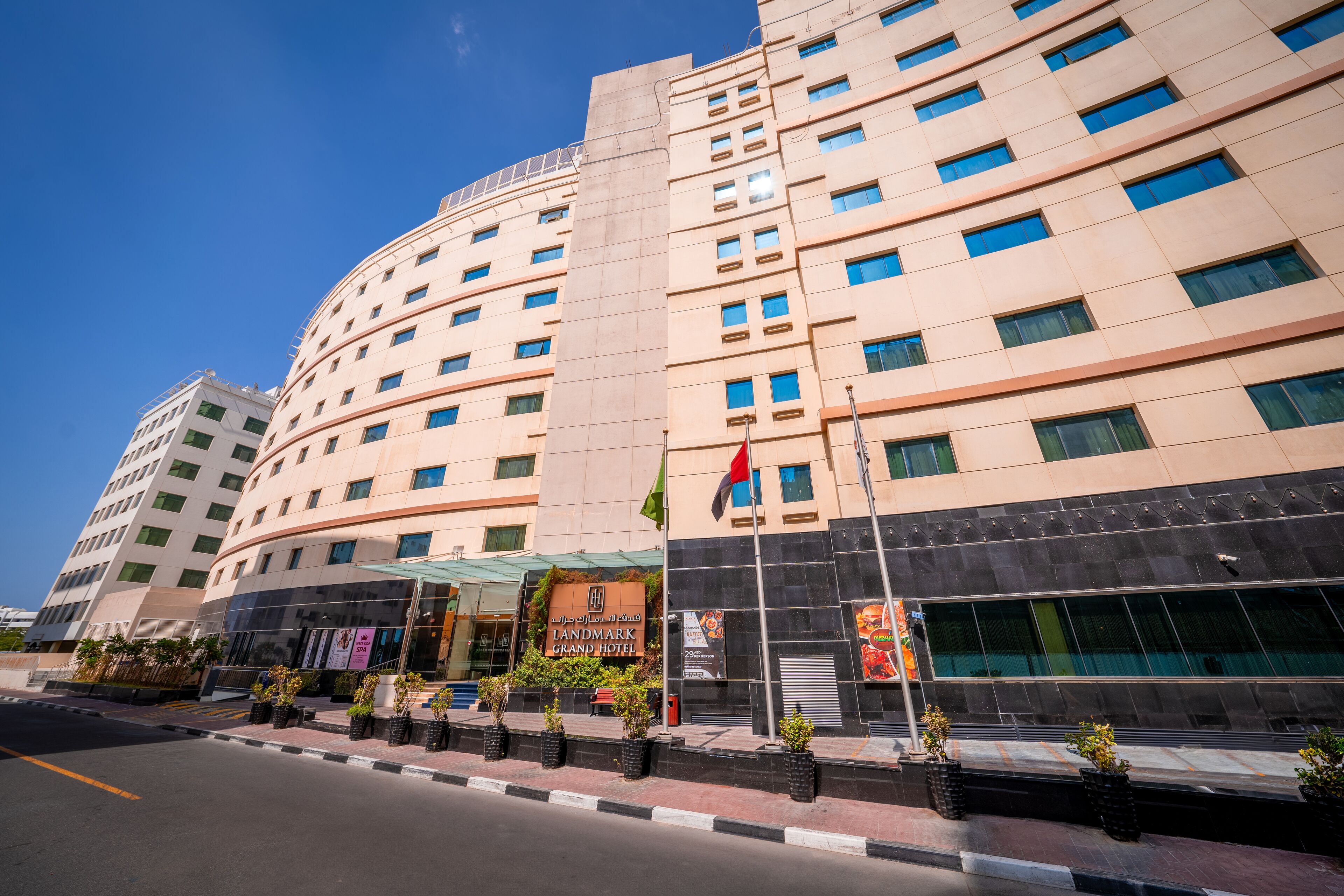 A multi-story hotel with a curved facade, large windows, and a prominent entrance with a sign.