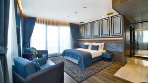 Habitación de hotel moderna con cama, zona de estar y vistas a la ciudad.
