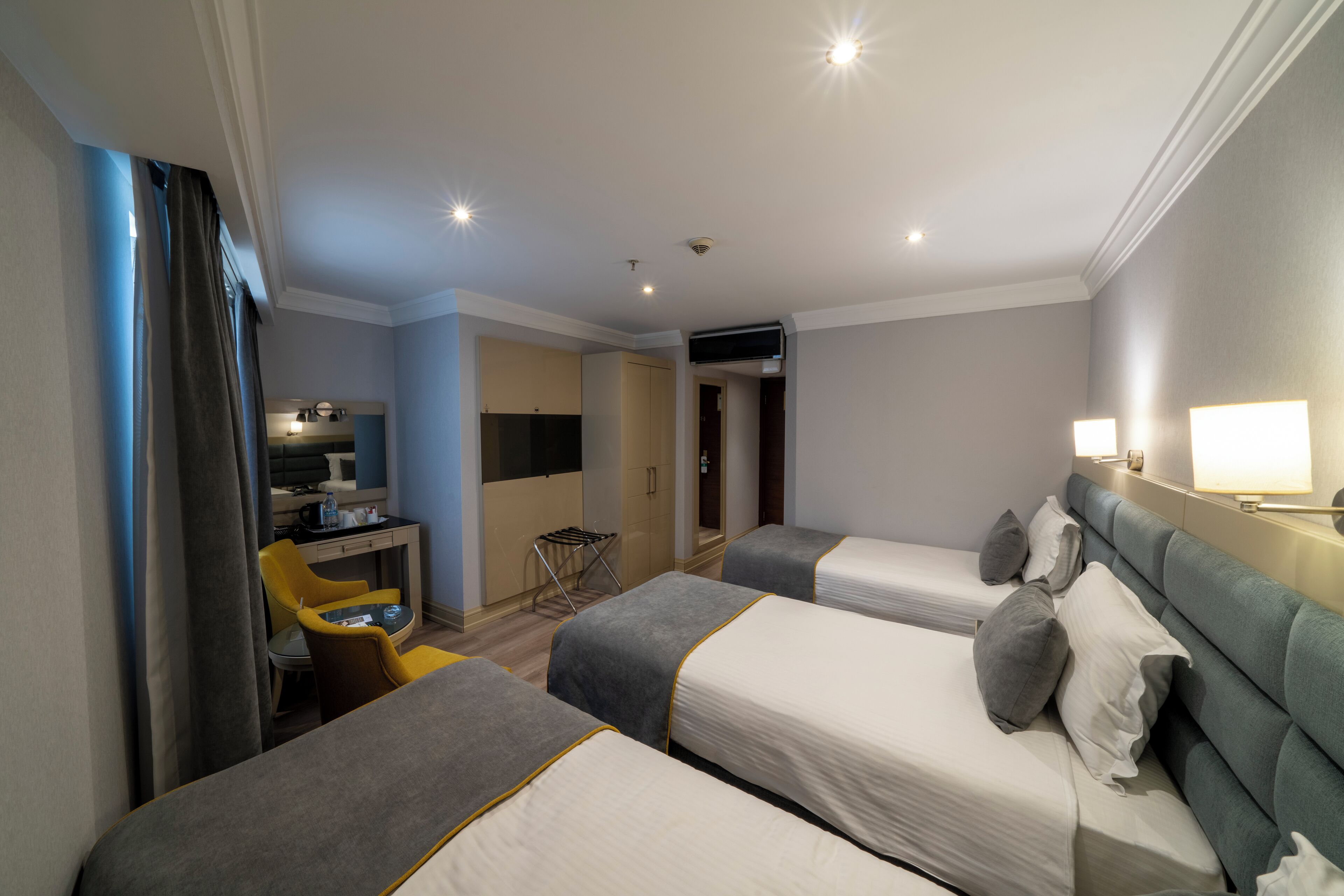 Habitación de hotel con dos camas, un escritorio y una silla.