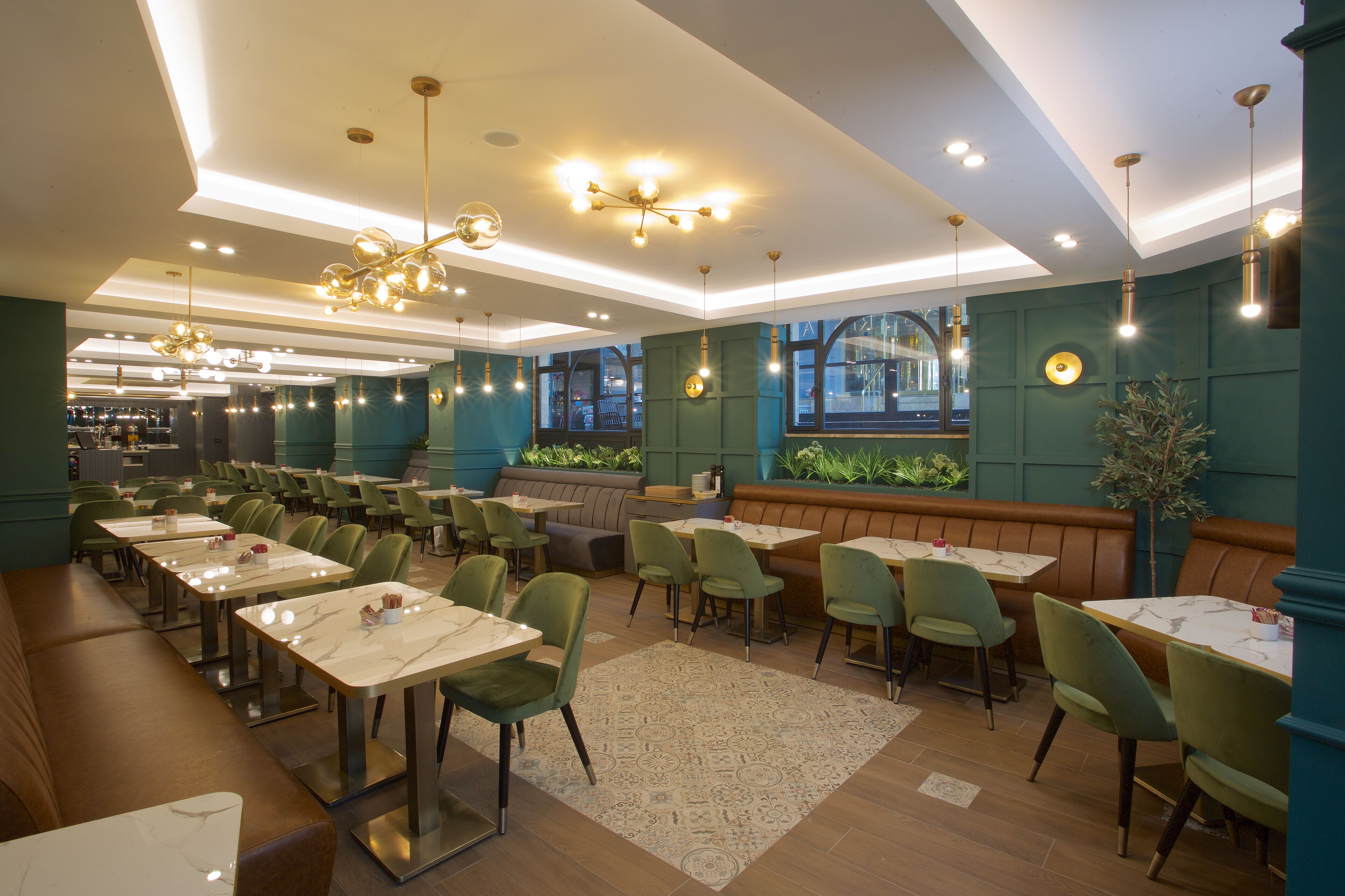Un restaurante con varias mesas y sillas, una zona de bar y un espacio de asiento con vistas al paisaje urbano.