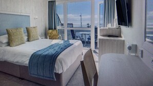 A modern hotel room with a large bed, a desk, and a flat-screen TV. - St Ives Hotel (Lytham St. Anne's)