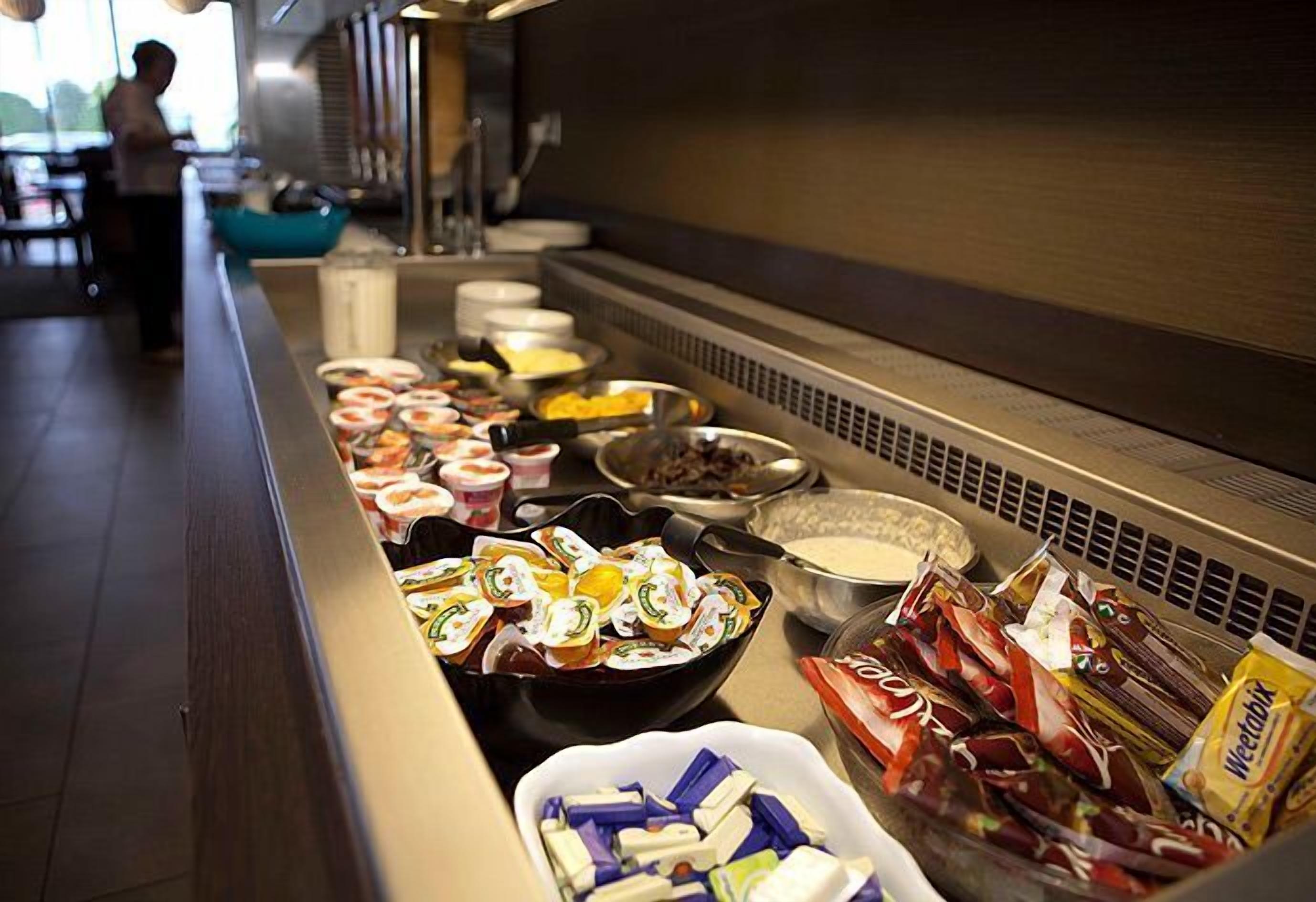 A buffet with various food items and condiments.