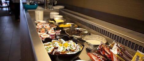 A buffet with various food items and condiments.