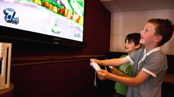 Two individuals playing a video game on a large screen.