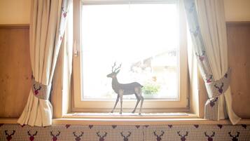 Una ventana con cortinas y una decoración de ciervo.