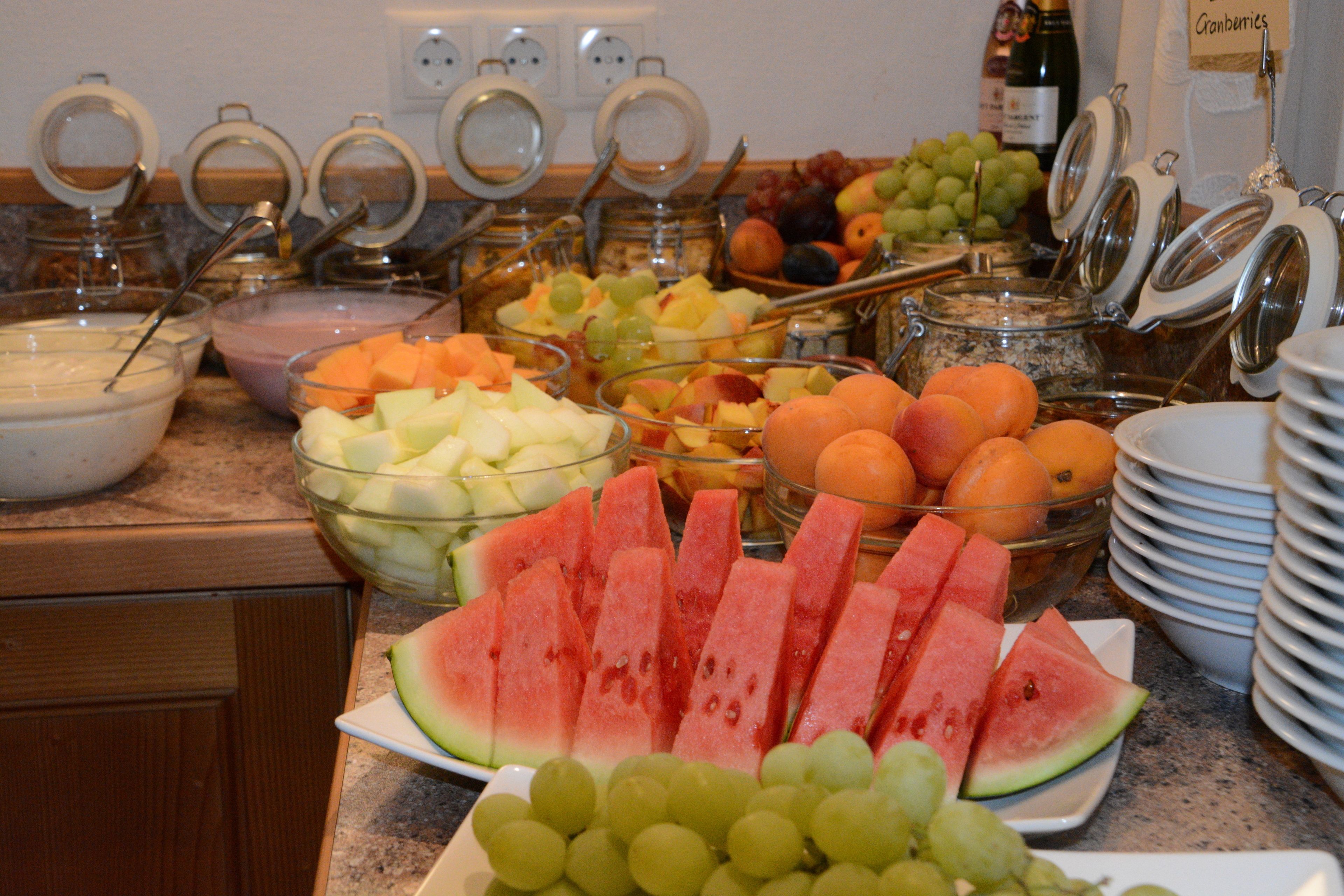Un bufé con diversas frutas y bebidas.