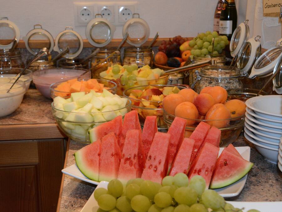 Un bufé con diversas frutas y bebidas.