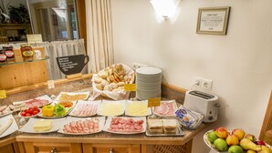 Un bufé con diversos alimentos y un bol de fruta.