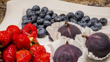 A white plate with strawberries, blueberries, and figs.