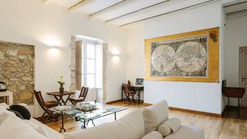 Ein geräumiges Wohnzimmer mit Steinwand, Holzmöbeln und einer großen Karte an der Wand.