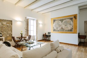 Cozy living area with a high ceiling, exposed beams, and a large framed map on the wall.
