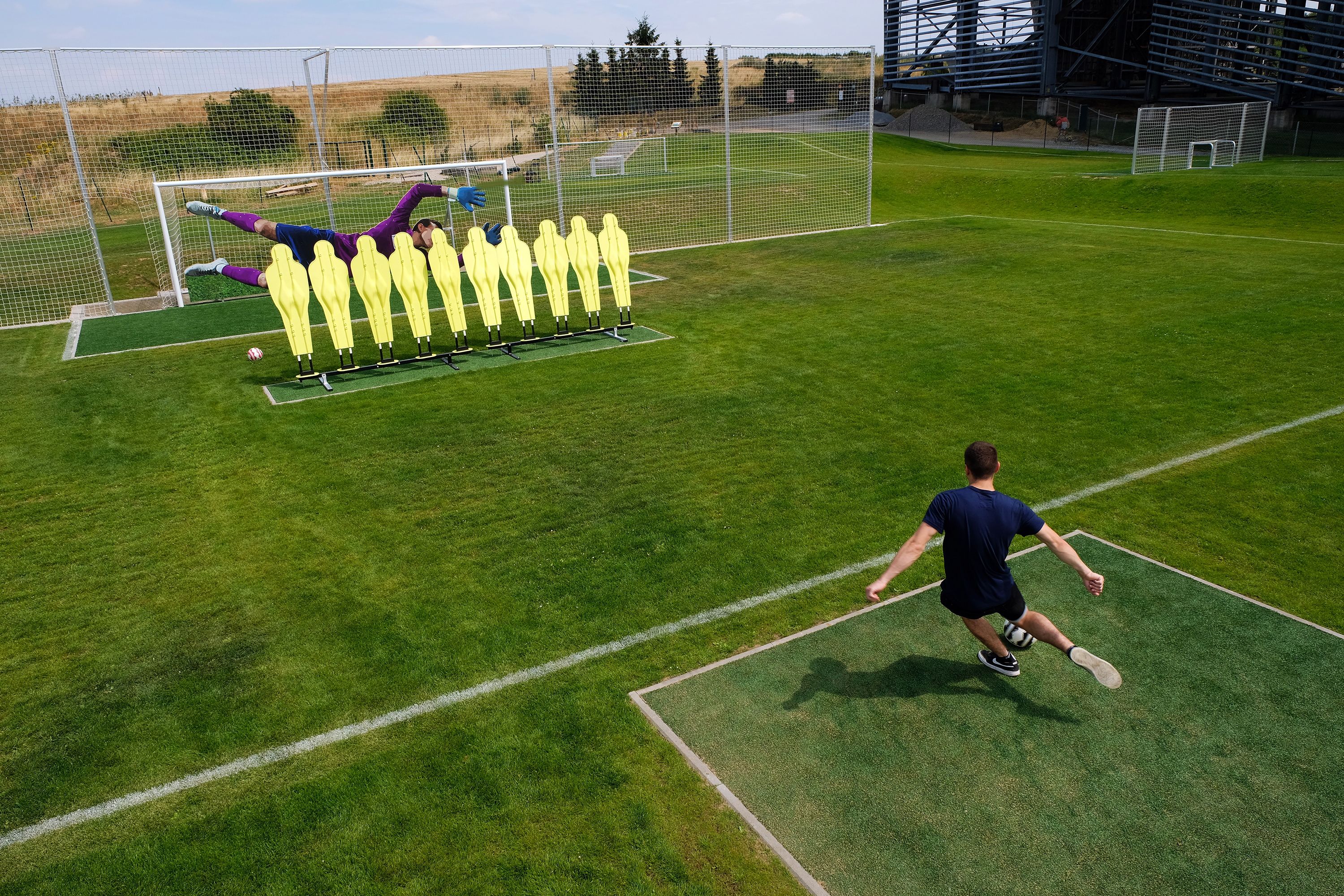 Een voetbalveld met doelpaal, net en trainingsmaterialen.