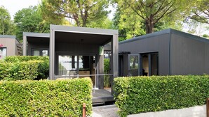 A modern, compact building with a glass entrance and a deck area. - Concept Village Piccola Gardiola (San Felice del Benaco)