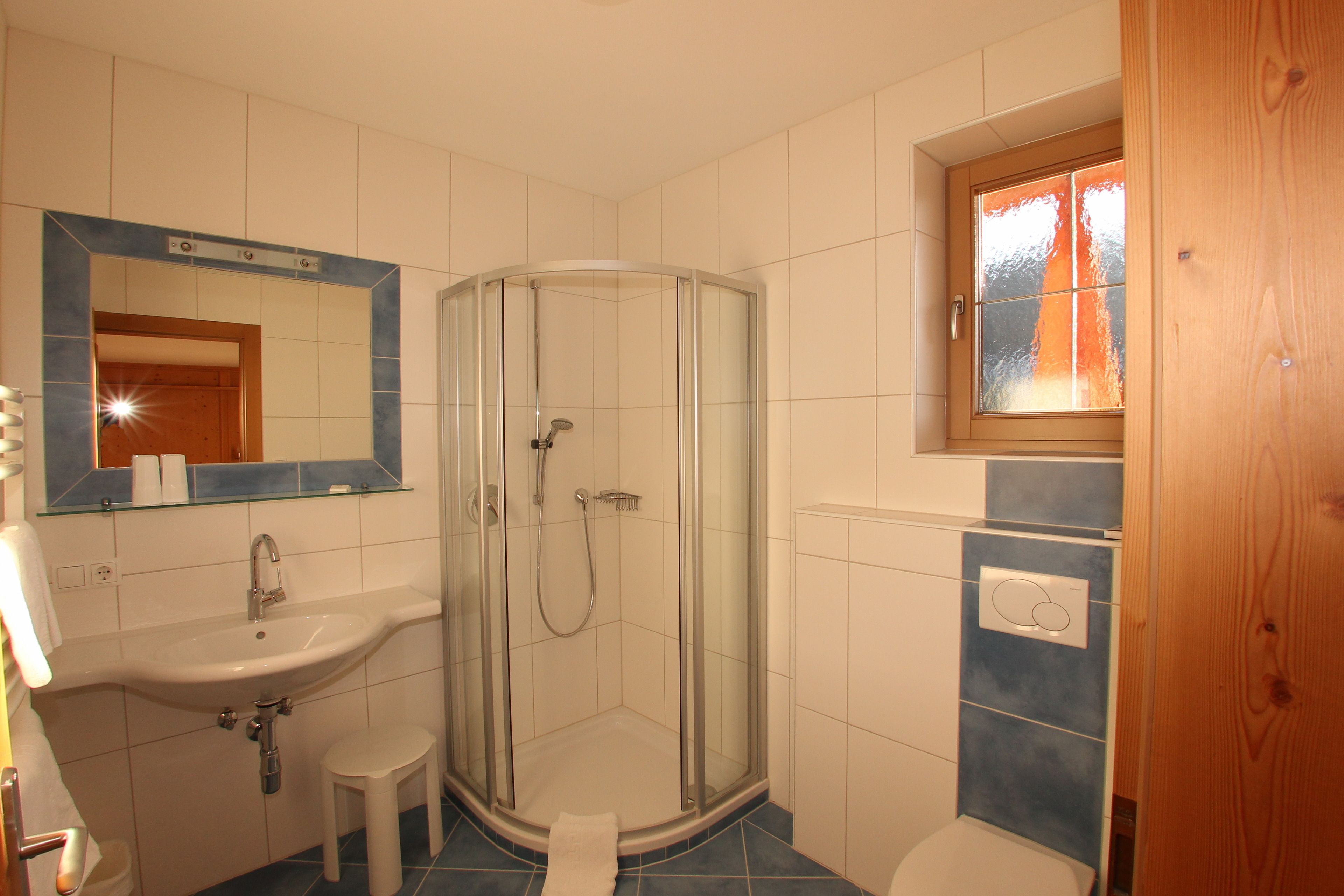 Une salle de bain avec une douche à parois de verre, un lavabo et des toilettes.