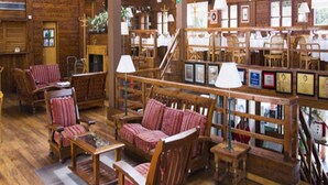 A spacious lodge with wooden interiors, multiple seating areas, and a staircase leading to upper levels. - Rincon de los Andes Resort (San Martín de los Andes)