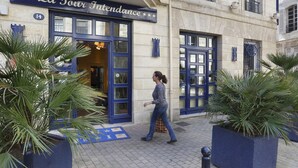 Un immeuble sur lequel on peut lire l’inscription « La Tour Intendance », avec le numéro « 14 » au-dessus de l’entrée.