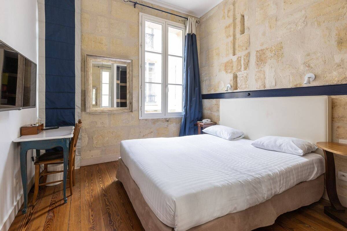 Ein Schlafzimmer mit einem großen Bett, einem Schreibtisch und einem Sessel.