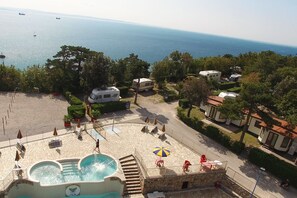 A resort with a swimming pool, outdoor seating, and RVs. - Camping Village Mare Pineta Baia Sistiana (Duino-Aurisina)