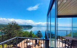 A balcony with a clear view of a coastal landscape, including a body of water and distant hills. - Camping Village Mare Pineta Baia Sistiana (Duino-Aurisina)