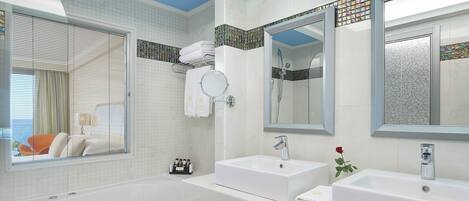 Ein modernes Badezimmer mit einer Badewanne, zwei Waschbecken und einem großen Spiegel.