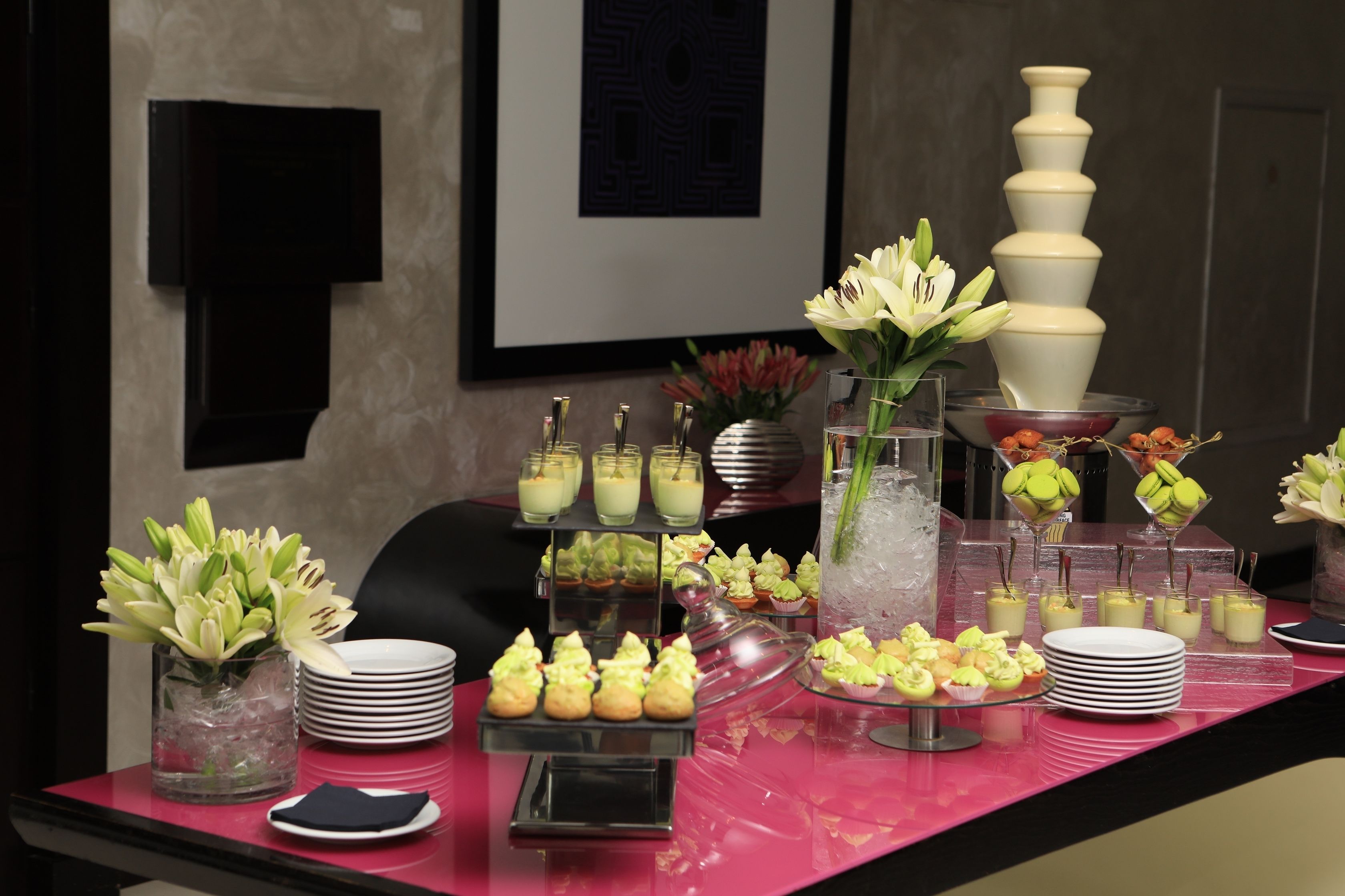 Una mesa de buffet con diferentes alimentos y un jarrón decorativo con flores.