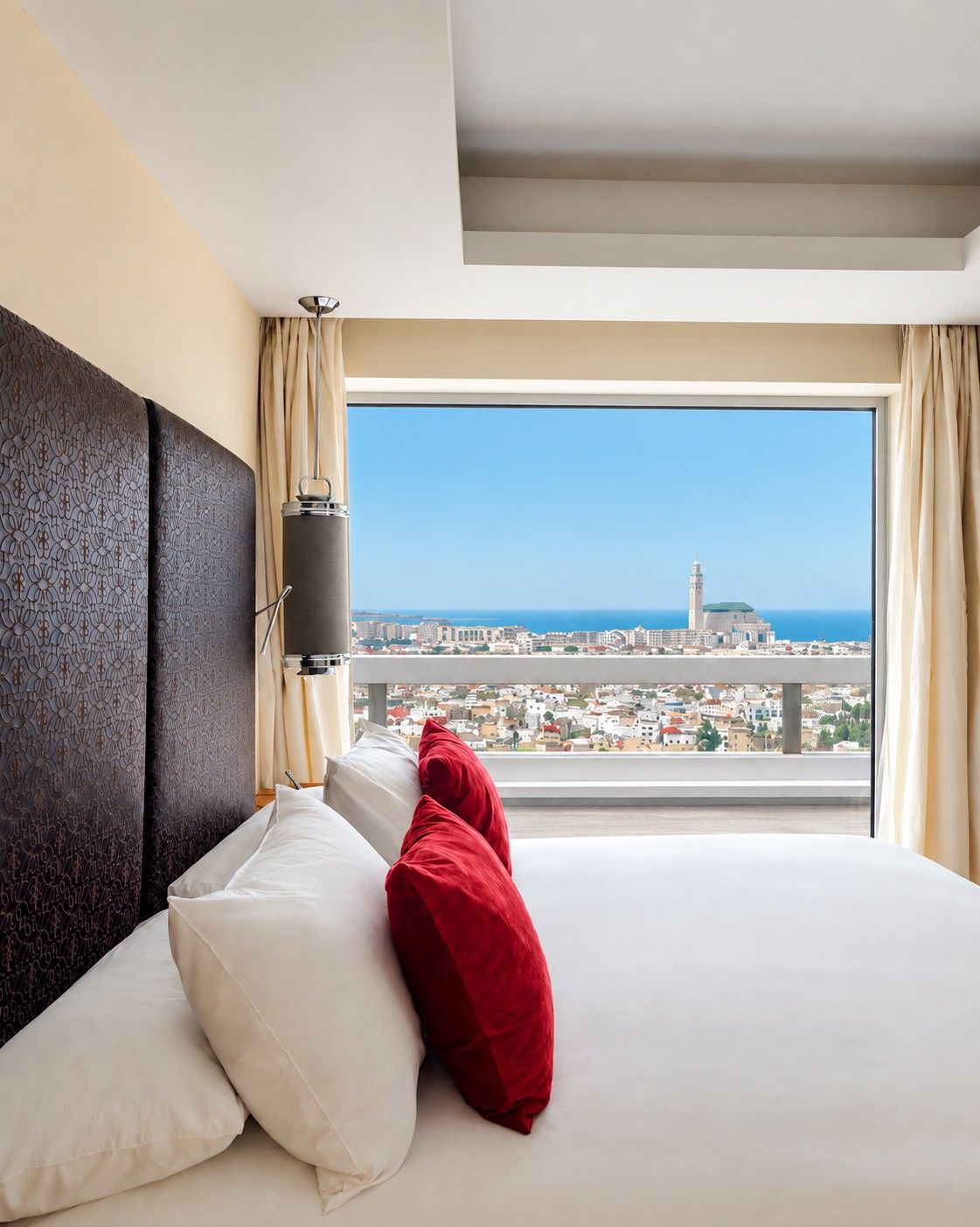 Une chambre d’hôtel avec un grand lit, une vue sur la ville et une fenêtre avec des rideaux.