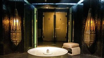 Relax in a serene space with a central basin and sleek, metallic accents.