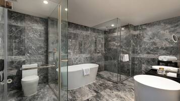 A modern bathroom with a glass-enclosed shower, a freestanding bathtub, and a round sink.