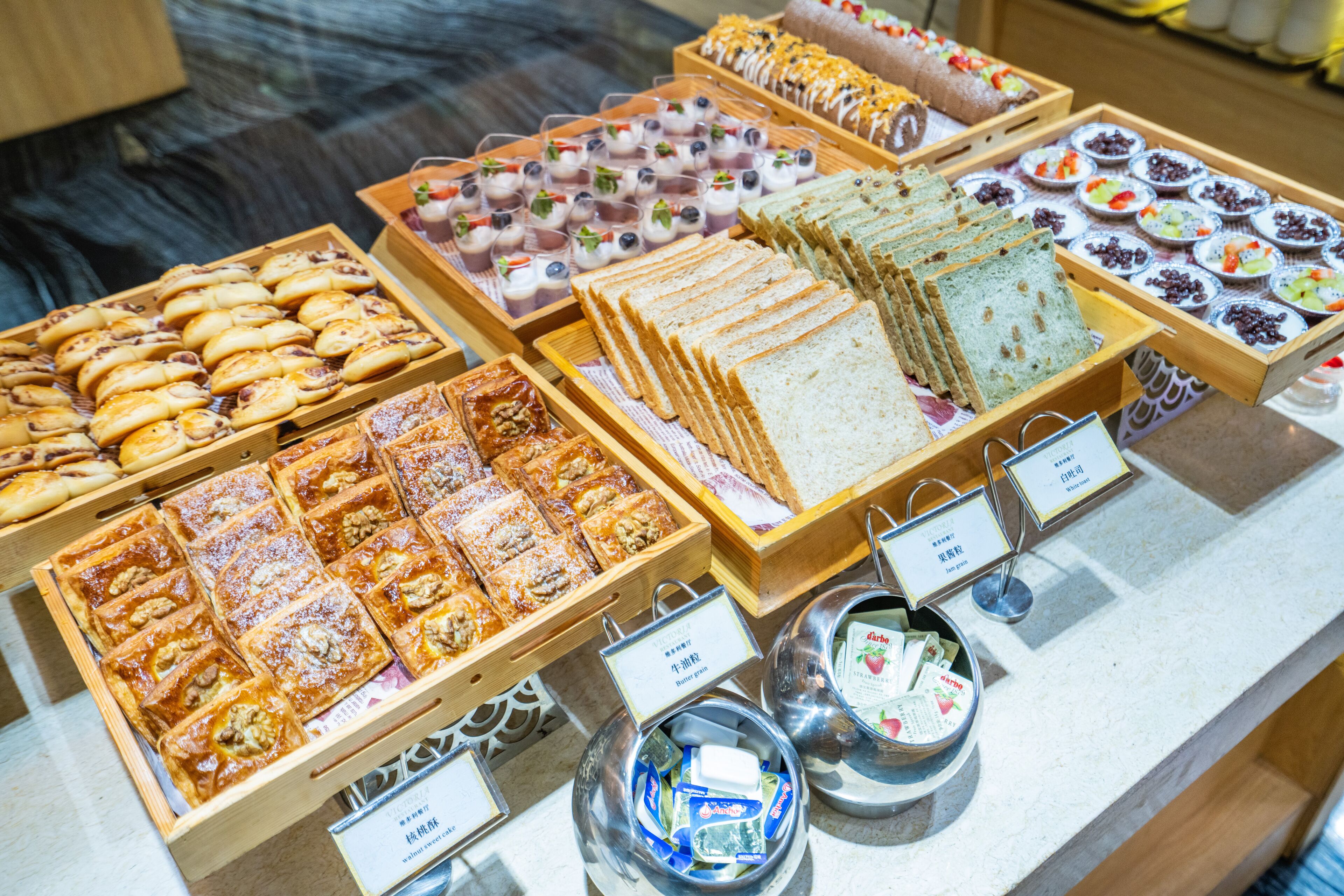 A buffet with various food items including pastries, sandwiches, and desserts.