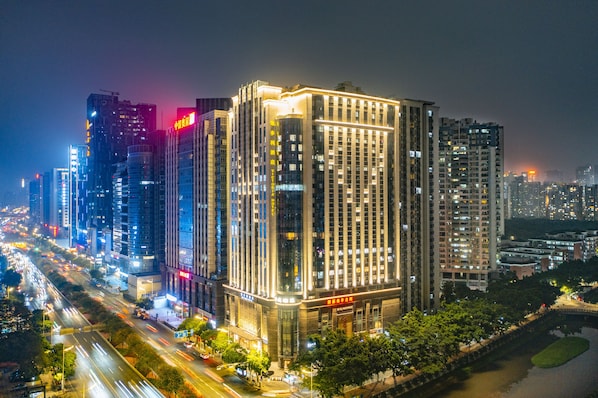 Un hôtel de grande hauteur, avec de nombreux étages, de grandes fenêtres et une façade bien éclairée.