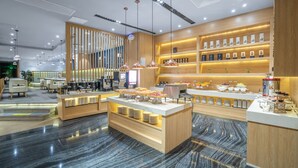Vestíbulo moderno de hotel con un mostrador de recepción central, zona de estar y exhibición de servicios.