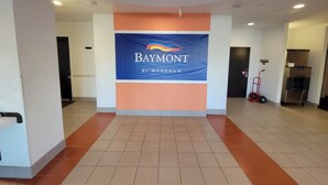 A hotel lobby with a large sign reading "Baymont by Wyndham".