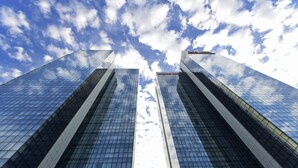 Two tall, modern buildings with reflective glass facades and a clear sky with clouds. - ibis Abu Dhabi Gate (Abu Dhabi)