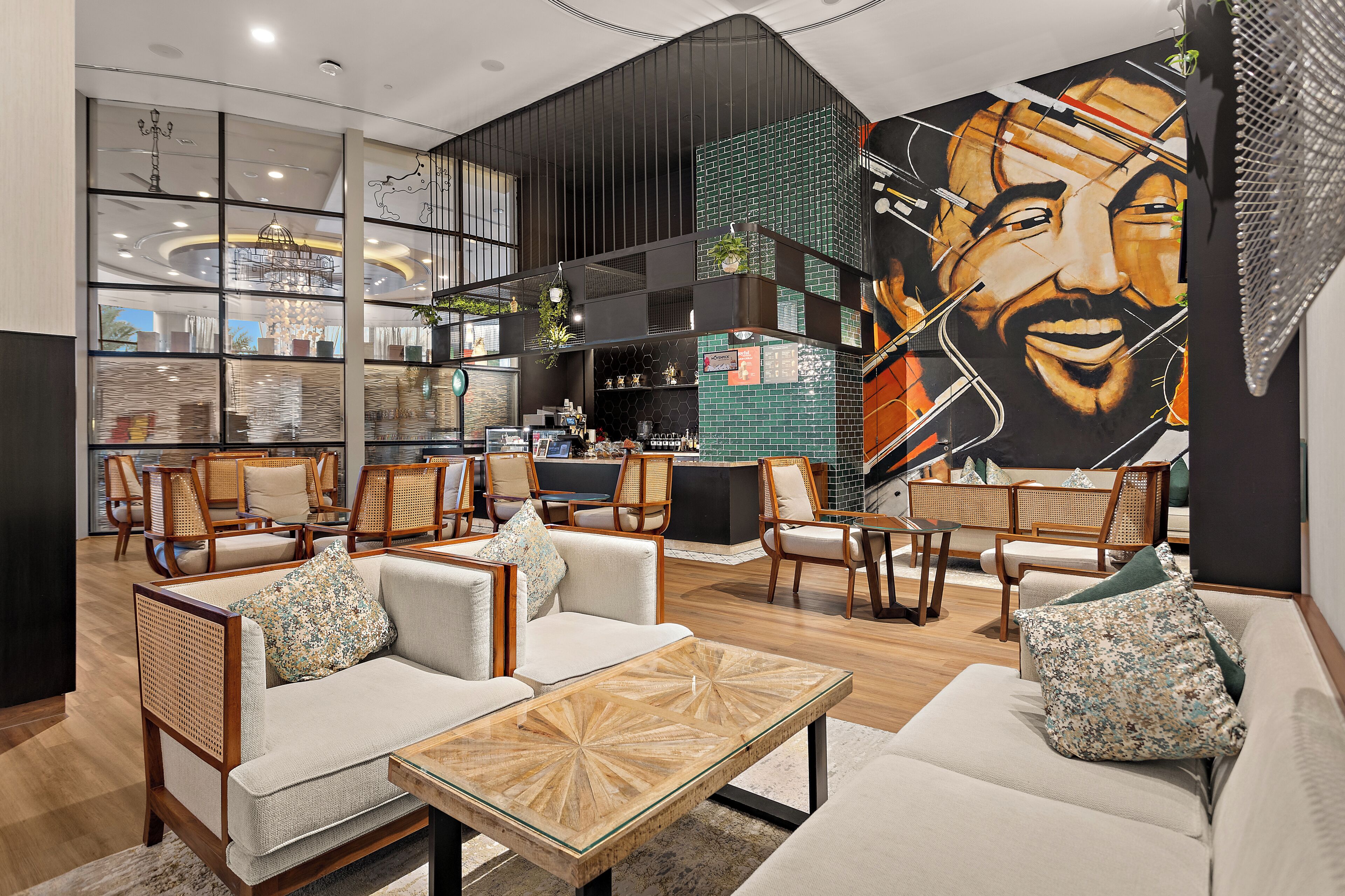 Eine geräumige Lobby mit Sitzgelegenheiten, einer Bar und einem großen Wandgemälde.