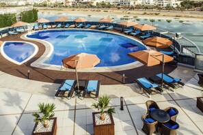 Outdoor pool, pool umbrellas, sun loungers - ibis Abu Dhabi Gate (Abu Dhabi)