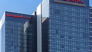 Zwei Hochhäuser mit Glasfassaden und Beschilderung, die darauf hinweist, dass sie zur ibis Hotelkette gehören.