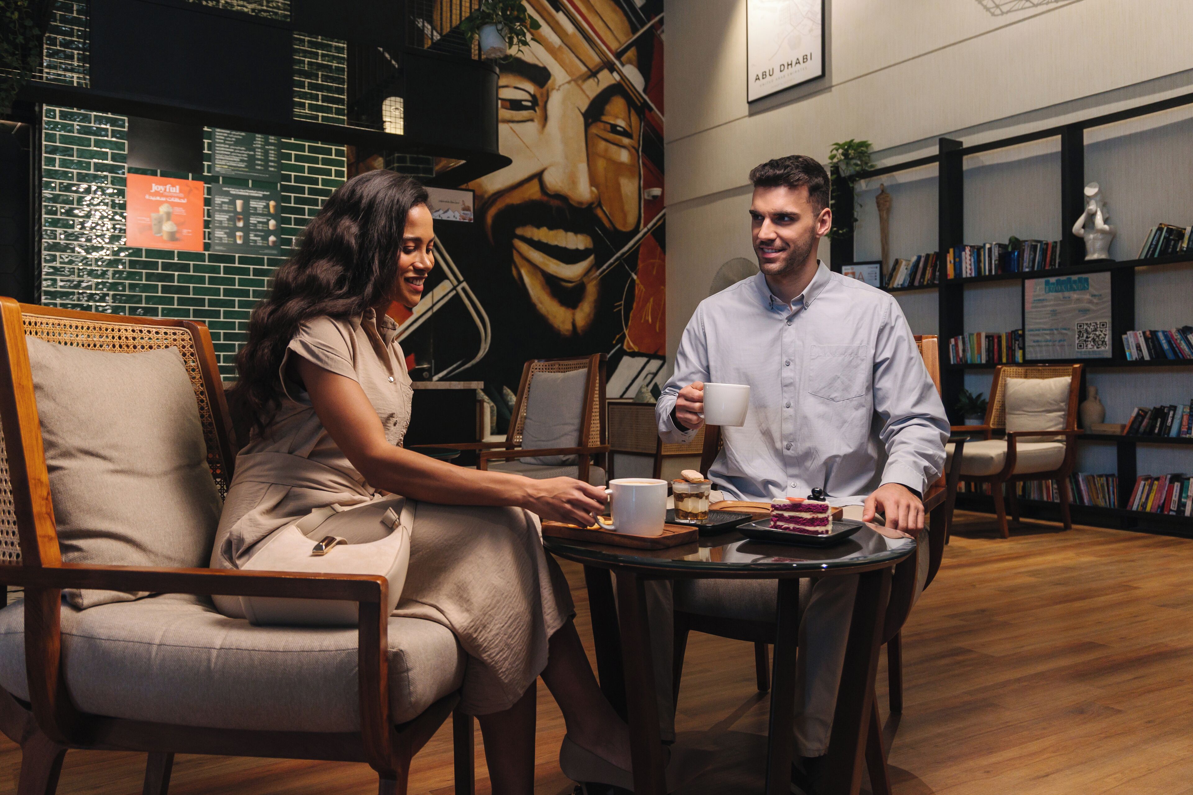 A cafe setting with a mural, bookshelves, and a wooden floor.