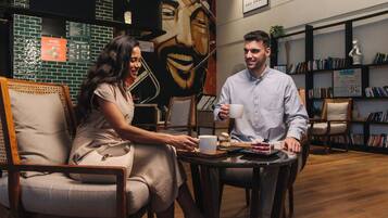 A cafe setting with a mural, bookshelves, and a wooden floor.