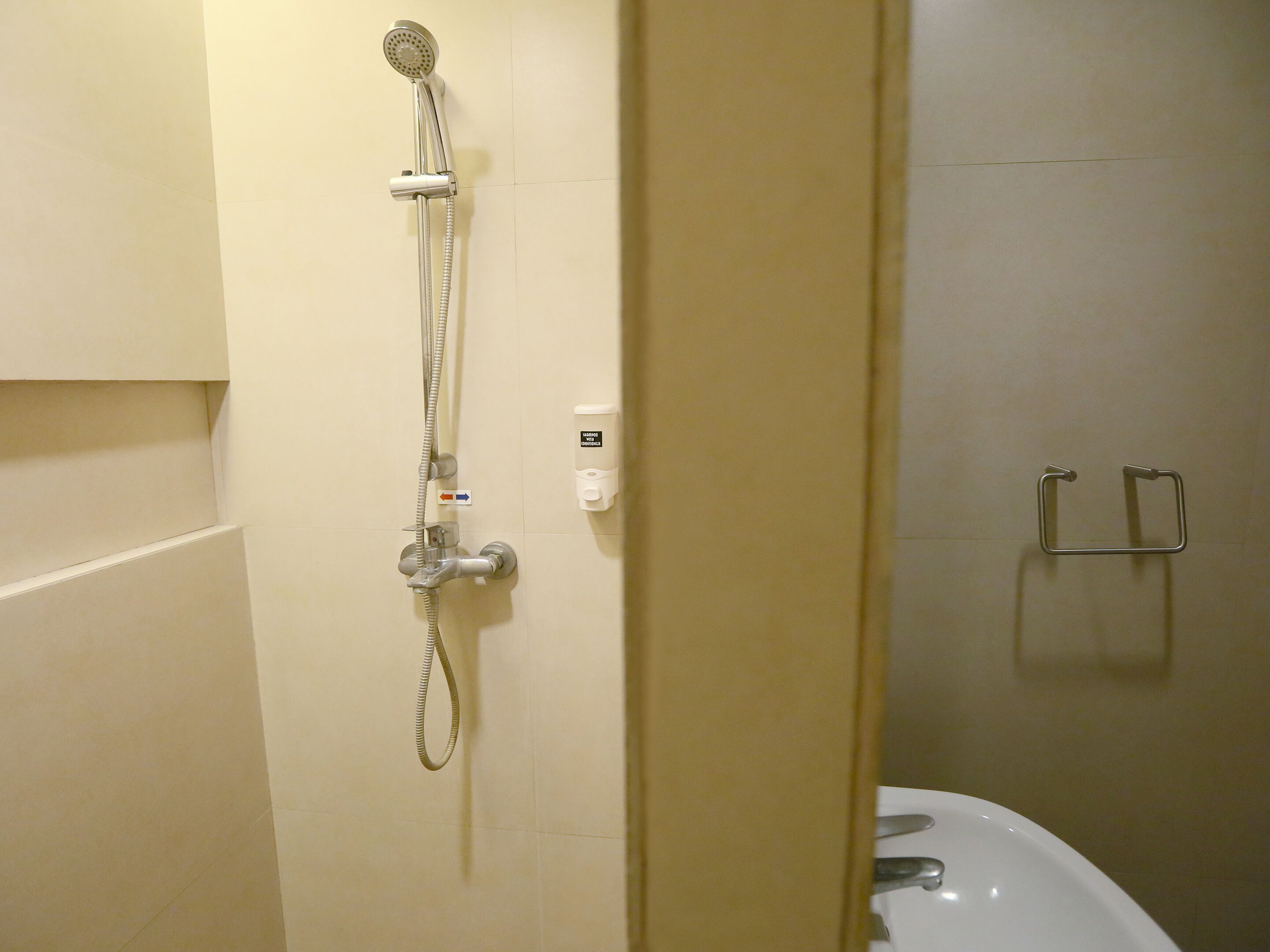 A bathroom with a shower, a toilet, and a towel rack.