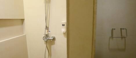 A bathroom with a shower, a toilet, and a towel rack.