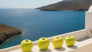 A balcony with a view of the sea and hills.