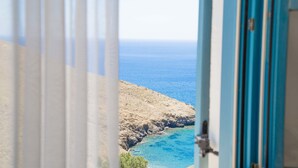 A coastal view through a window with a view of the sea and rocky terrain.