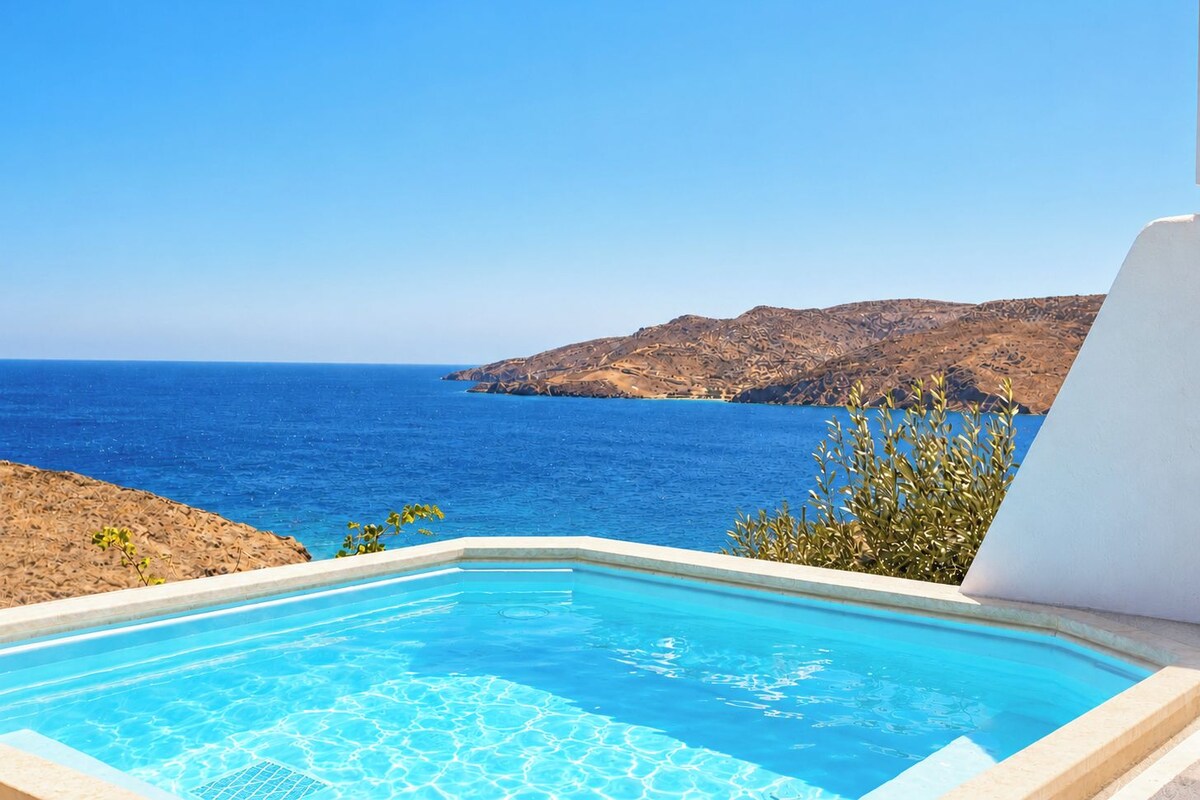 Una piscina azul cristalina con vistas al mar y un paisaje rocoso.